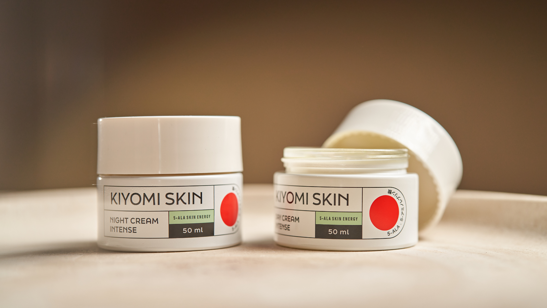 Two Kiyomi Skin night cream jars on a beige surface, one open and one closed, both 50 ml.
