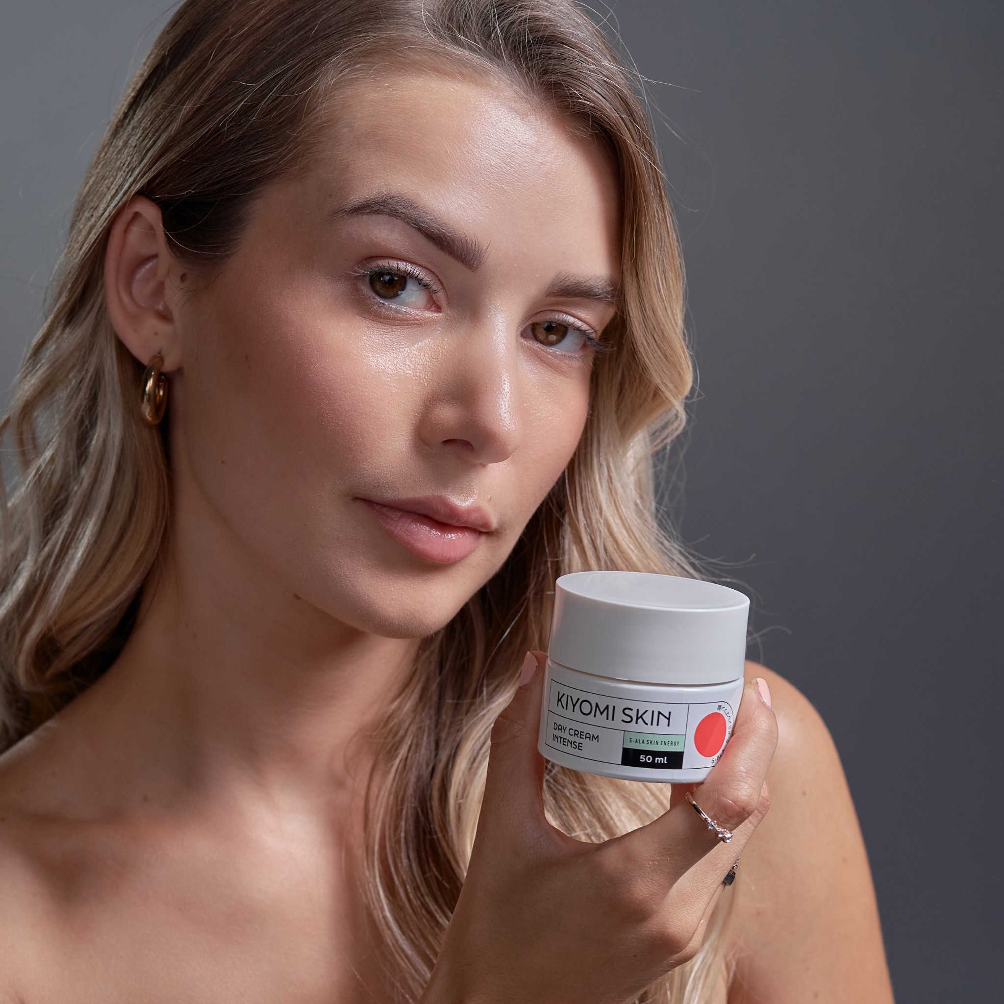 Woman with long blonde hair holding a jar of Day Cream Intense, looking at the camera—perfect for intensive Gesichtspflege and ideal for empfindliche Haut.