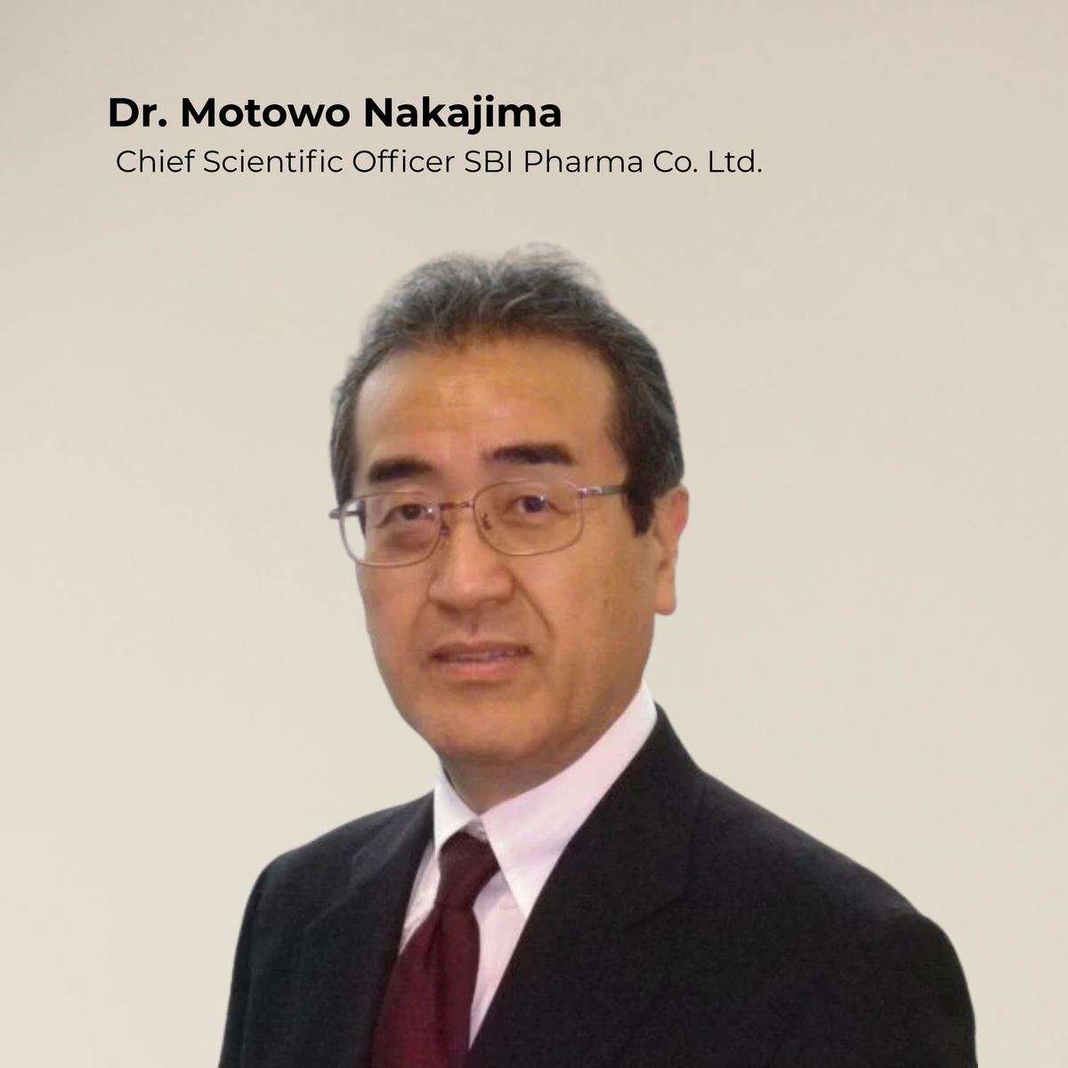 Dr. Motowo Nakajima, der eine Brille trägt und einen Anzug, steht vor einem schlichten Hintergrund, auf dem sein Titel zu sehen ist.