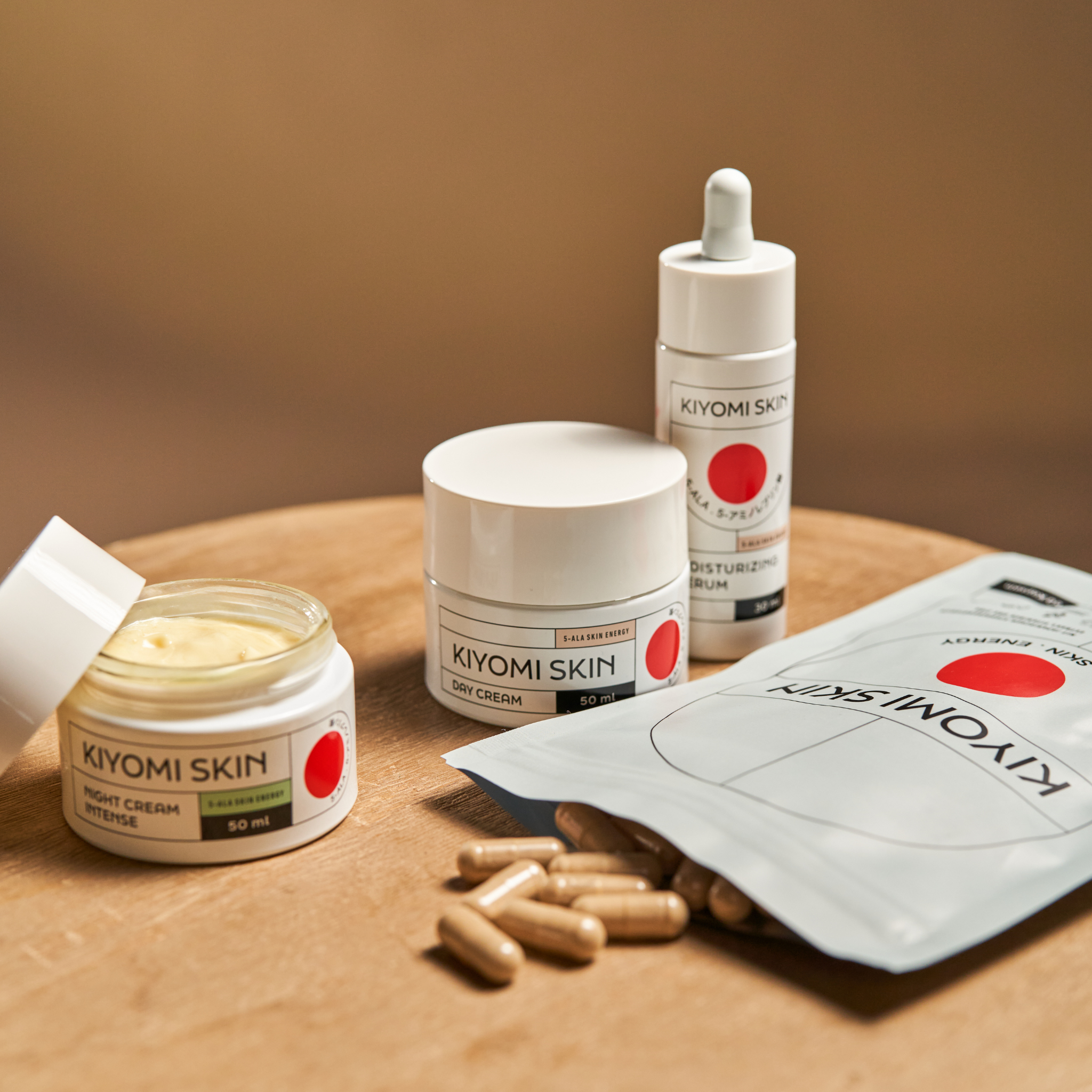 Skin Energy Essentials Inner and Outer Radiance, along with other skincare items, are elegantly arranged on a wooden surface against a neutral background.